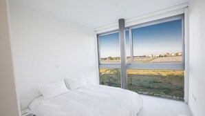 A bedroom with a large window, a bed, and a nightstand. - Villa Charlize, Luxury and Contemporary 3BDR Kapparis Villa with Private Pool (Protaras)