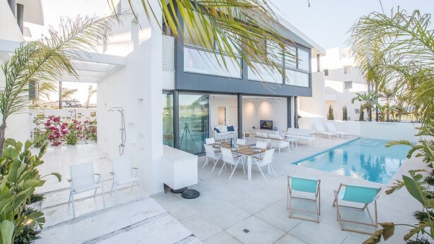 A modern house with a swimming pool, outdoor seating, and lush greenery. - Villa Charlize, Luxury and Contemporary 3BDR Kapparis Villa with Private Pool (Protaras)