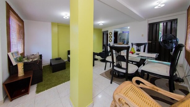 A modern living room with a dining area, featuring a sofa set, a coffee table, and a dining table with chairs. - Apartment in Cartagena Colombia. (Cartagena)