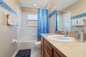 A bathroom with a bathtub, toilet, and sink.