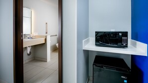A hotel room with a white sink, a microwave on a white shelf, and a black appliance below. - Holiday Inn Express & Suites Bend South by IHG (Bend)