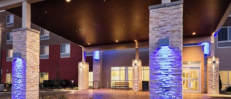 A hotel entrance with stone pillars, a covered walkway, and a fire lane.