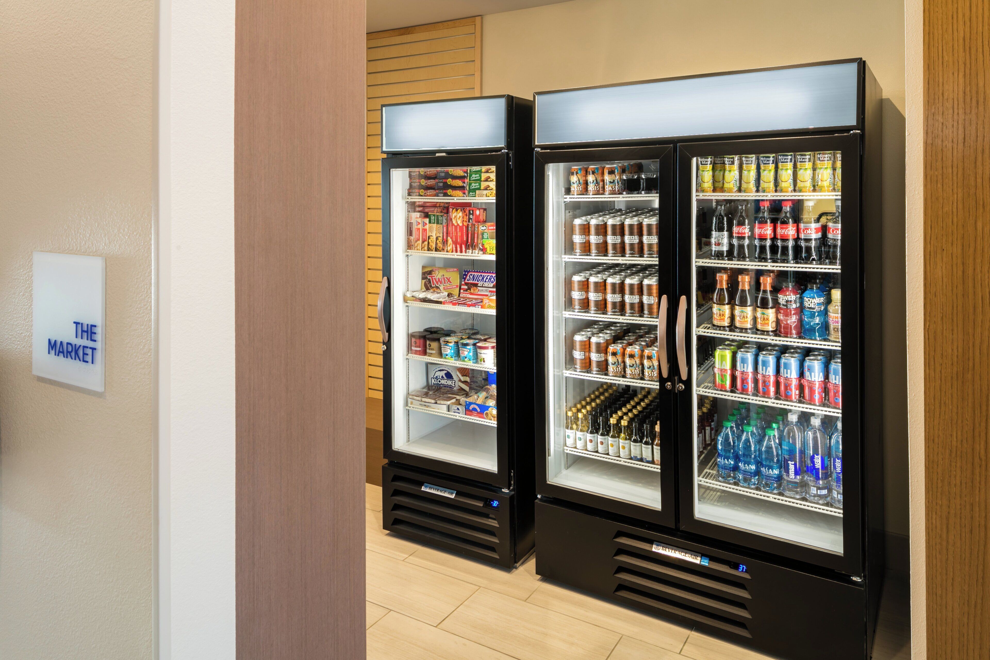 Deux distributeurs automatiques de boissons proposent une variété de boissons et d’en-cas.