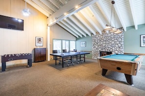 Enjoy games and entertainment in this spacious room with a pool table, foosball table, and billiards table.