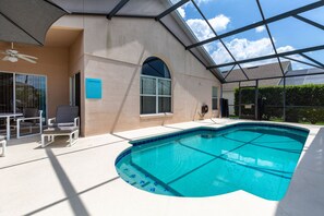 A swimming pool with a glass ceiling, a ceiling fan, and a poolside chair. - Haven Hideaway by VillaDirect (Davenport)