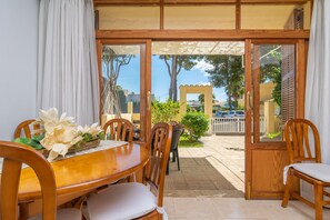 Enjoy meals in this dining area with a table and chairs, surrounded by a beautiful flower arrangement.