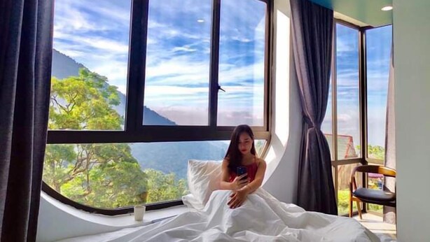 A room with a large window overlooking a mountainous landscape. - Le Vent Homestay Tam Dao (Tam Dao)