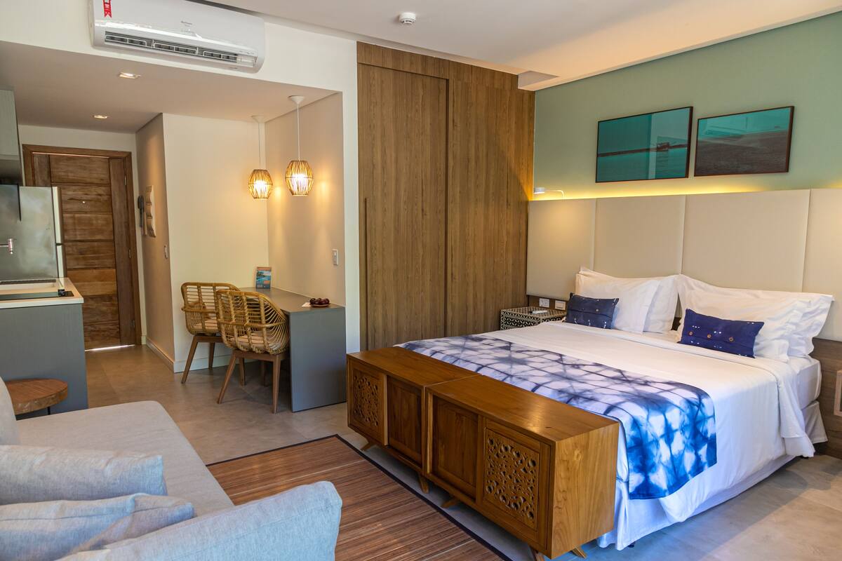 Una habitación de hotel moderna con una cama grande, un escritorio y una zona de estar.
