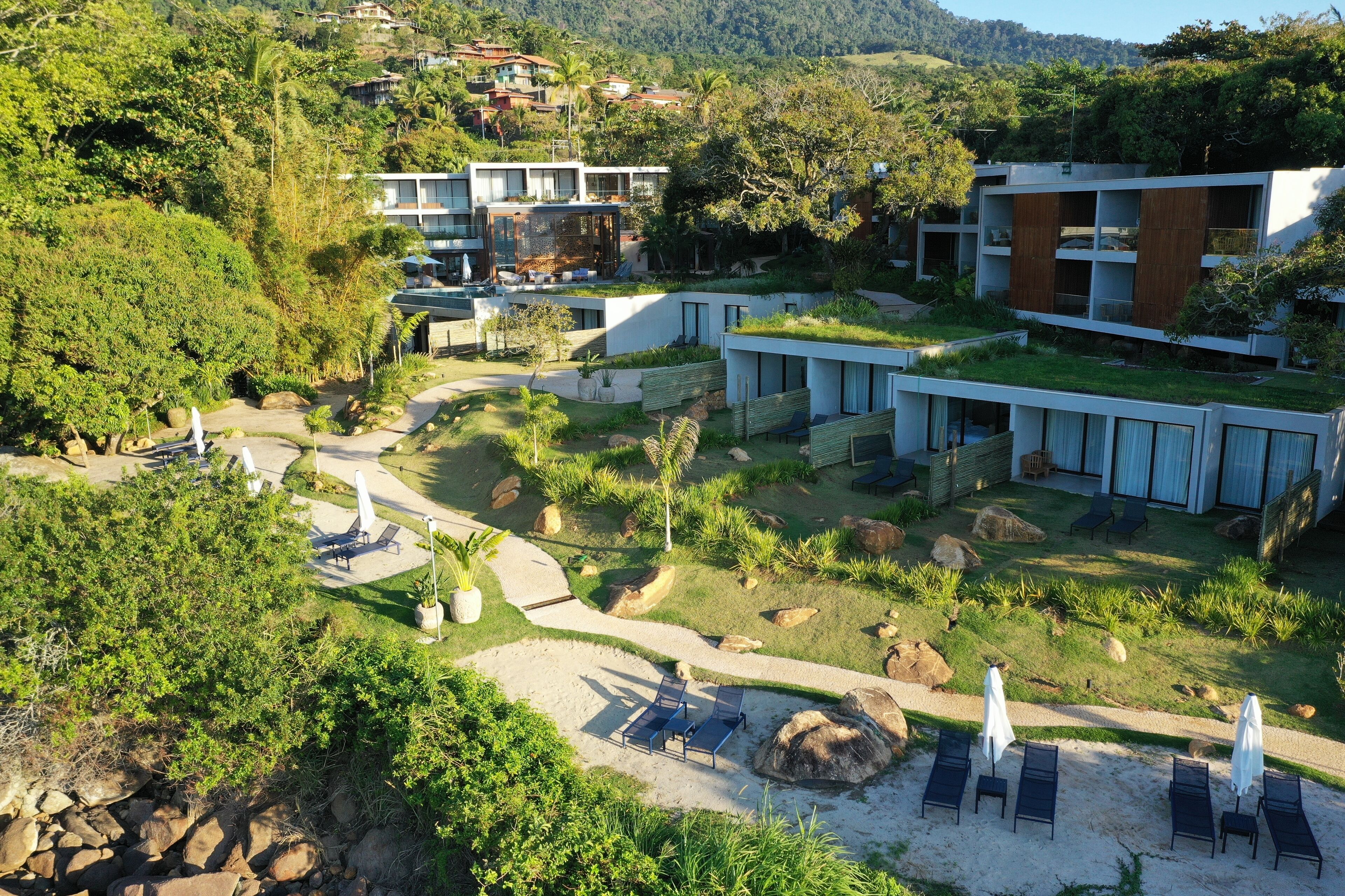 A modern resort with multiple buildings, outdoor seating areas, and a well-maintained garden.
