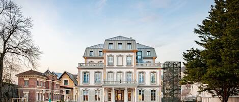 A large, multi-story building with a symmetrical facade, large windows, and a central entrance.