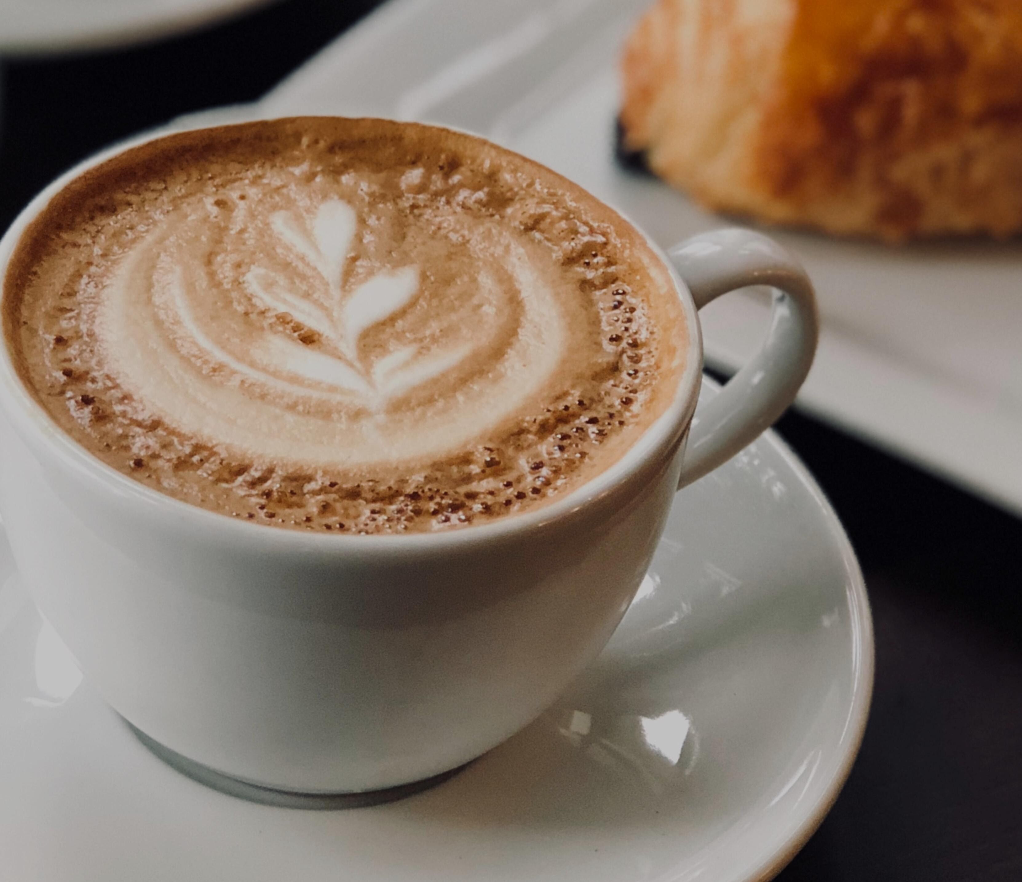 Eine Tasse Kaffee mit Latte-Art auf einem Untertasse.