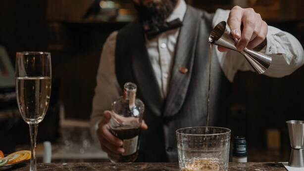A bartender pouring a drink into a glass. - Hotel Jägerhof Wörthersee - Only Adults Official Partner Amoria Spa (Krumpendorf am Woerther See)