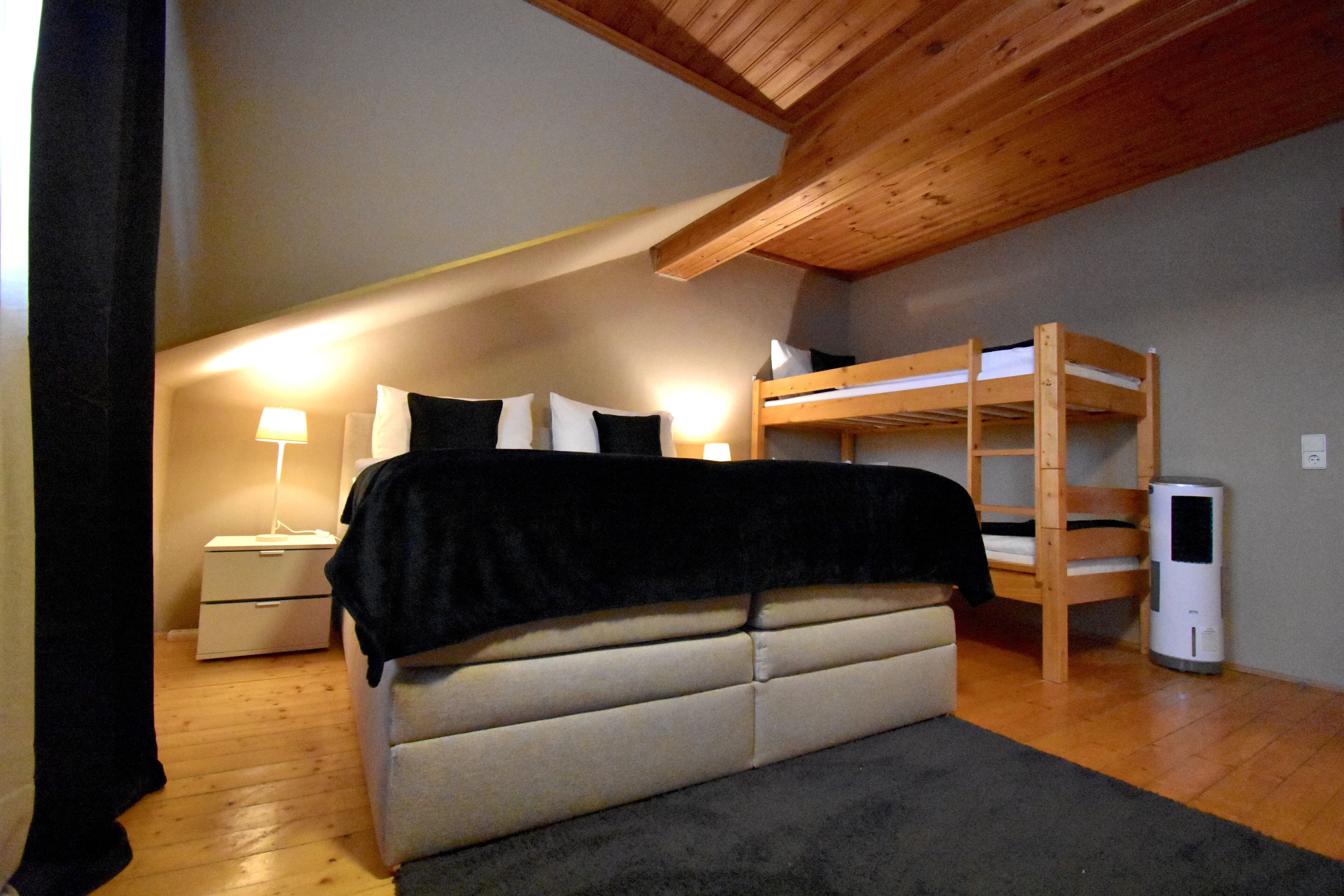 Ein Schlafzimmer mit einem Etagenbett, einem Nachttisch mit Lampe, einem Heizkörper und einem Kleiderschrank.