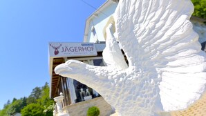 A white sculpture of an angel in front of a building with a sign that reads "Jägerhof Hotel Restaurant Bar". - Hotel Jägerhof Wörthersee - Only Adults Official Partner Amoria Spa (Krumpendorf am Woerther See)