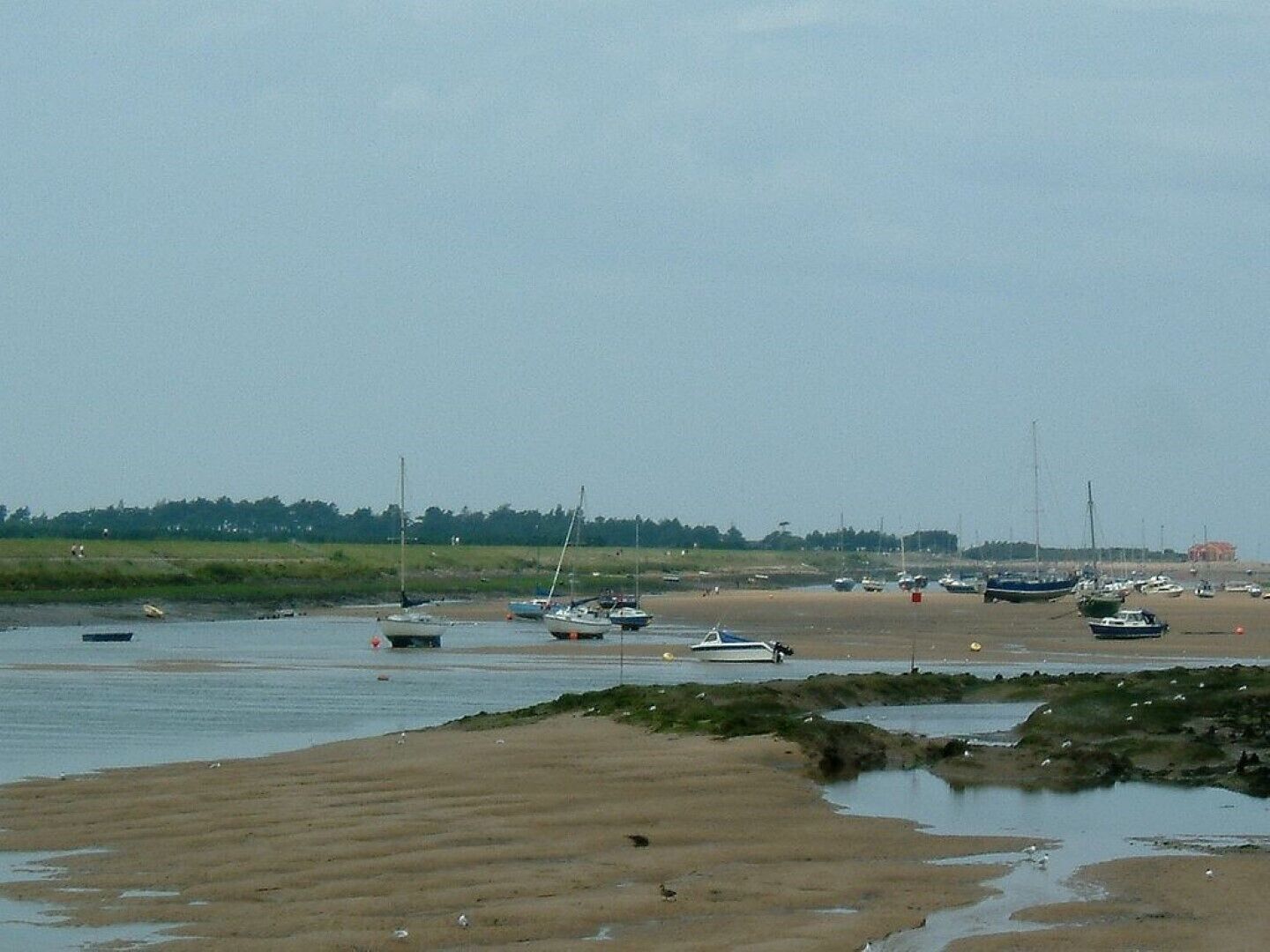 A coastal area with boats on the water and a sandy beach.