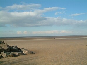 A wide sandy beach with large rocks in the foreground and a clear sky. - Cosy 17th century 1 bed cottage, perfect for couples and furry companions. (Great Snoring)