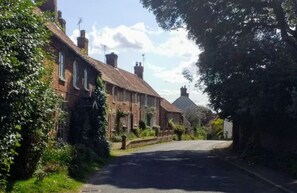 A quiet, narrow street lined with traditional brick houses, some with visible chimneys and ivy. - Cosy 17th century 1 bed cottage, perfect for couples and furry companions. (Great Snoring)
