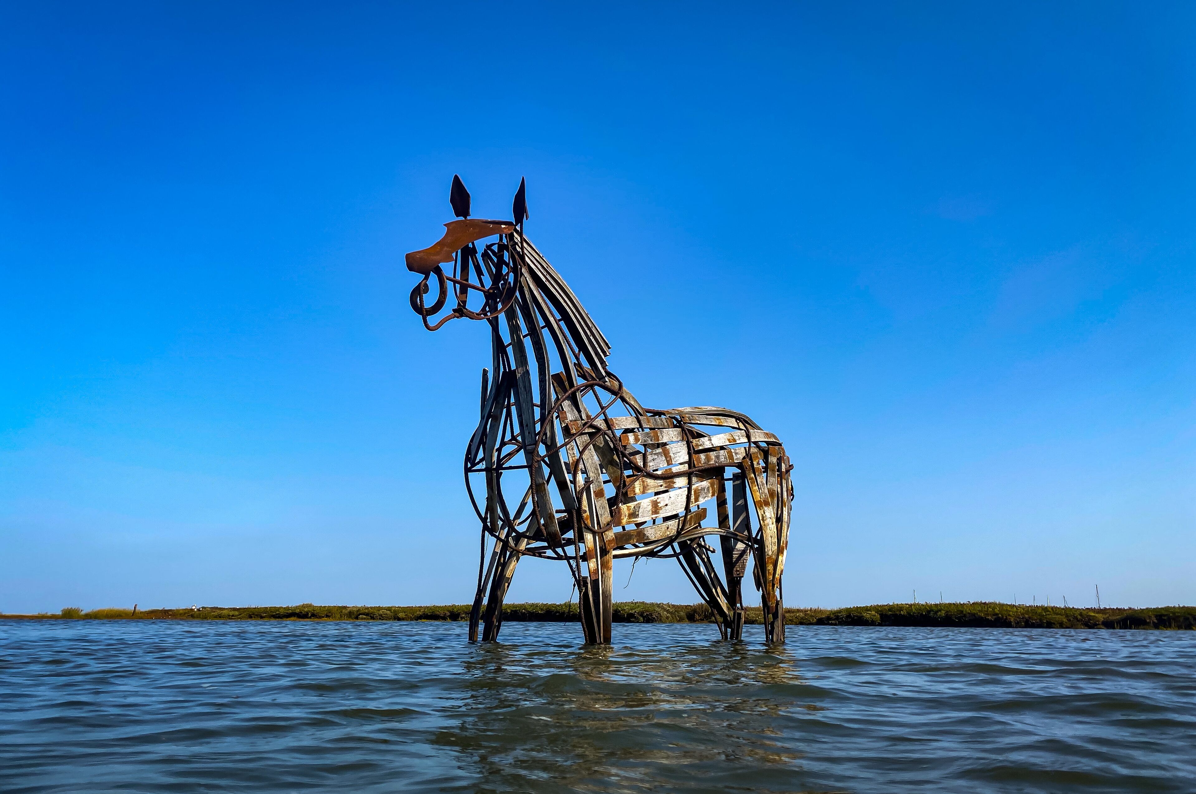 Une sculpture métallique représentant un cheval dans l’eau.