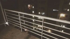 A balcony with a metal railing, a tiled floor, and a view of a building with illuminated windows at night. - Palermo Soho Apartment 2 (Buenos Aires)