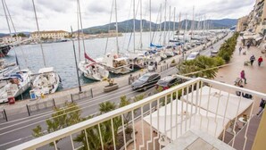 A marina with boats docked along the waterfront, a road parallel to the water, and buildings in the background. - Appartamenti La Calata (Portoferraio)