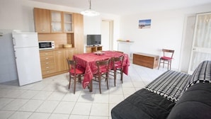 A compact living space with a kitchenette, dining area, and a bed. - Casa Malva (Portoferraio)