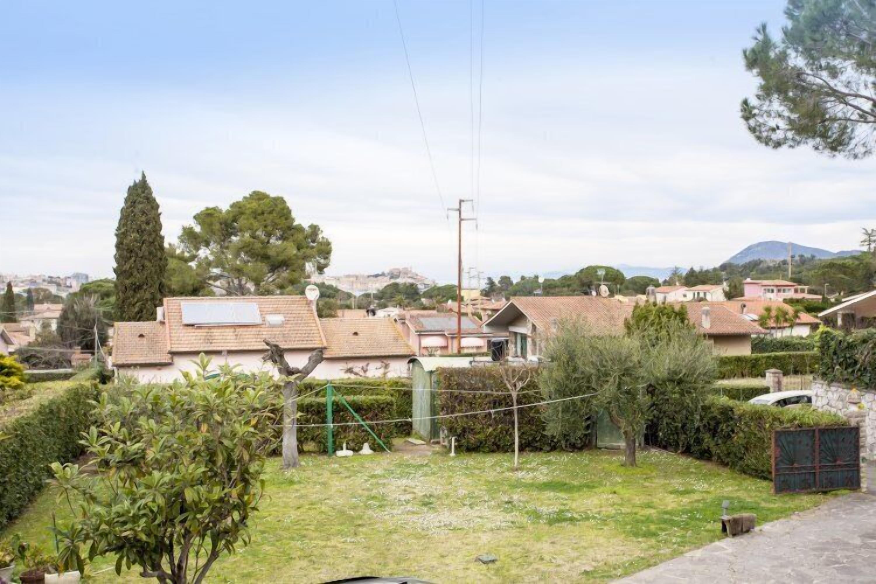 A residential area with houses, a grassy yard, and a mountain in the background.