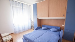 A bedroom with a bed, a chair, and a wardrobe. - Scoglietto (Portoferraio)