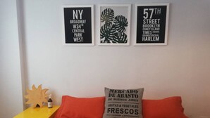 A bedroom with a bed, a nightstand, and three framed signs on the wall. - Paraguay & Salguero - Energy Home (Buenos Aires)