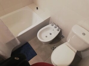 A bathroom with a bathtub, a bidet, and a toilet.