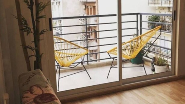 A room with a sofa, two yellow chairs, a large window, and a bamboo plant. - Paraguay & Salguero - Energy Home (Buenos Aires)