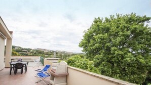 A balcony with a table, chairs, and a grill. - Bilocale Koala (Capoliveri)