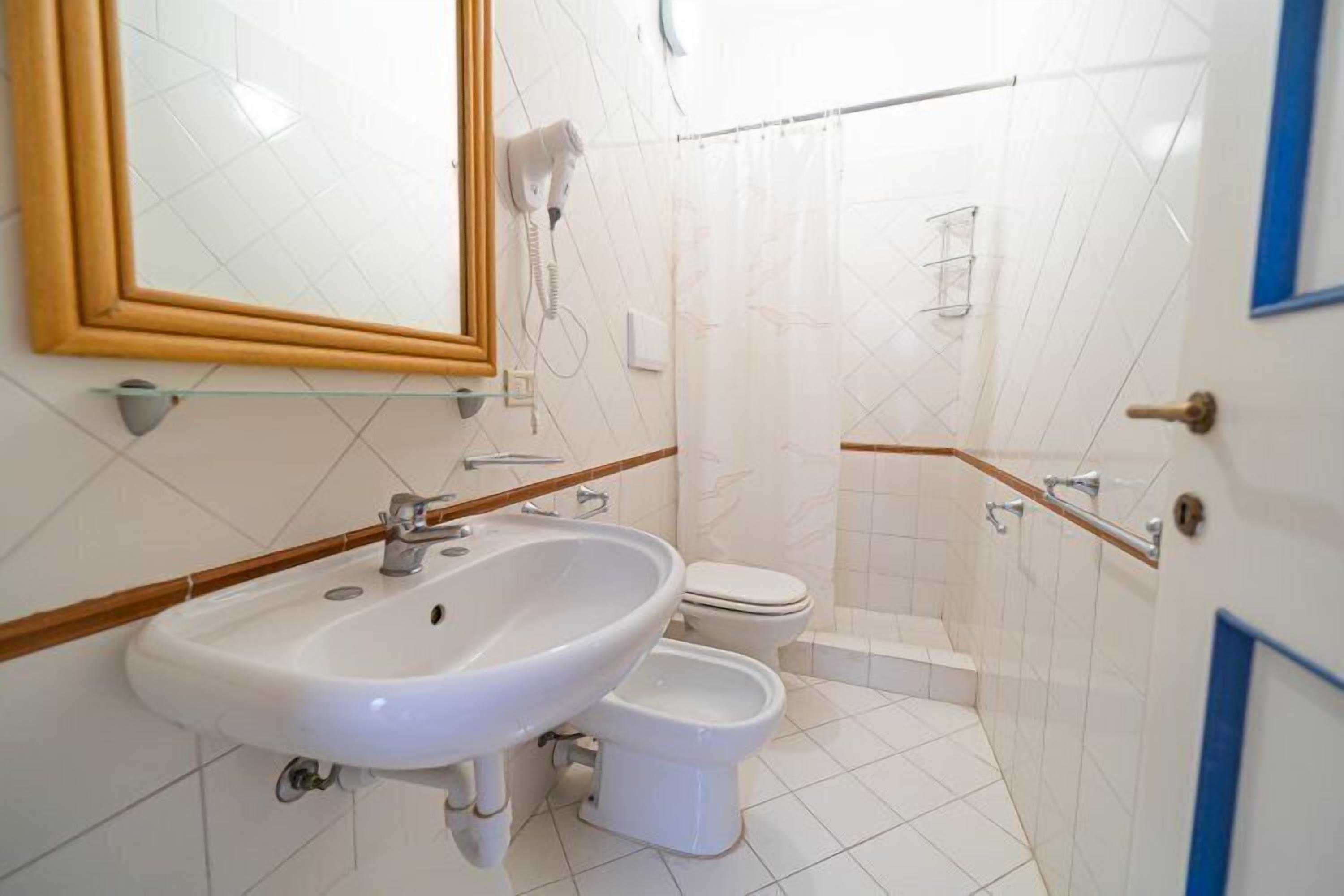 Ein Badezimmer mit Waschbecken, Toilette und Duschbereich.