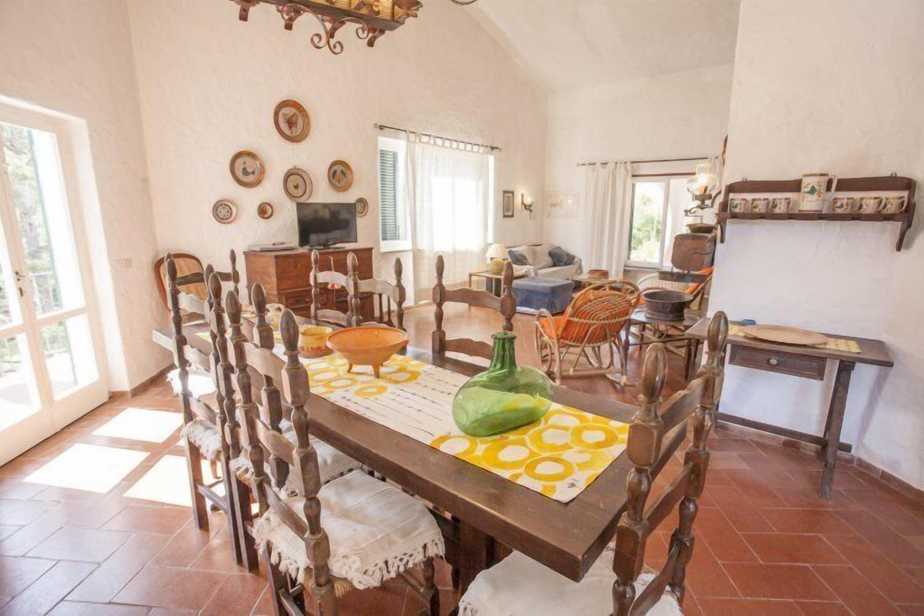 A dining area with a wooden table, chairs, and a patterned table runner.