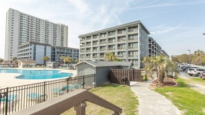 A residential building with a swimming pool, a fenced deck, and a sidewalk. - Birdie's Beachfront I - The only Oceanfront Condo to be at Myrtle Beach Resort (Myrtle Beach)