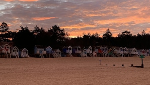 Une plage bordée de cabanes et dotée d’un rivage sablonneux.