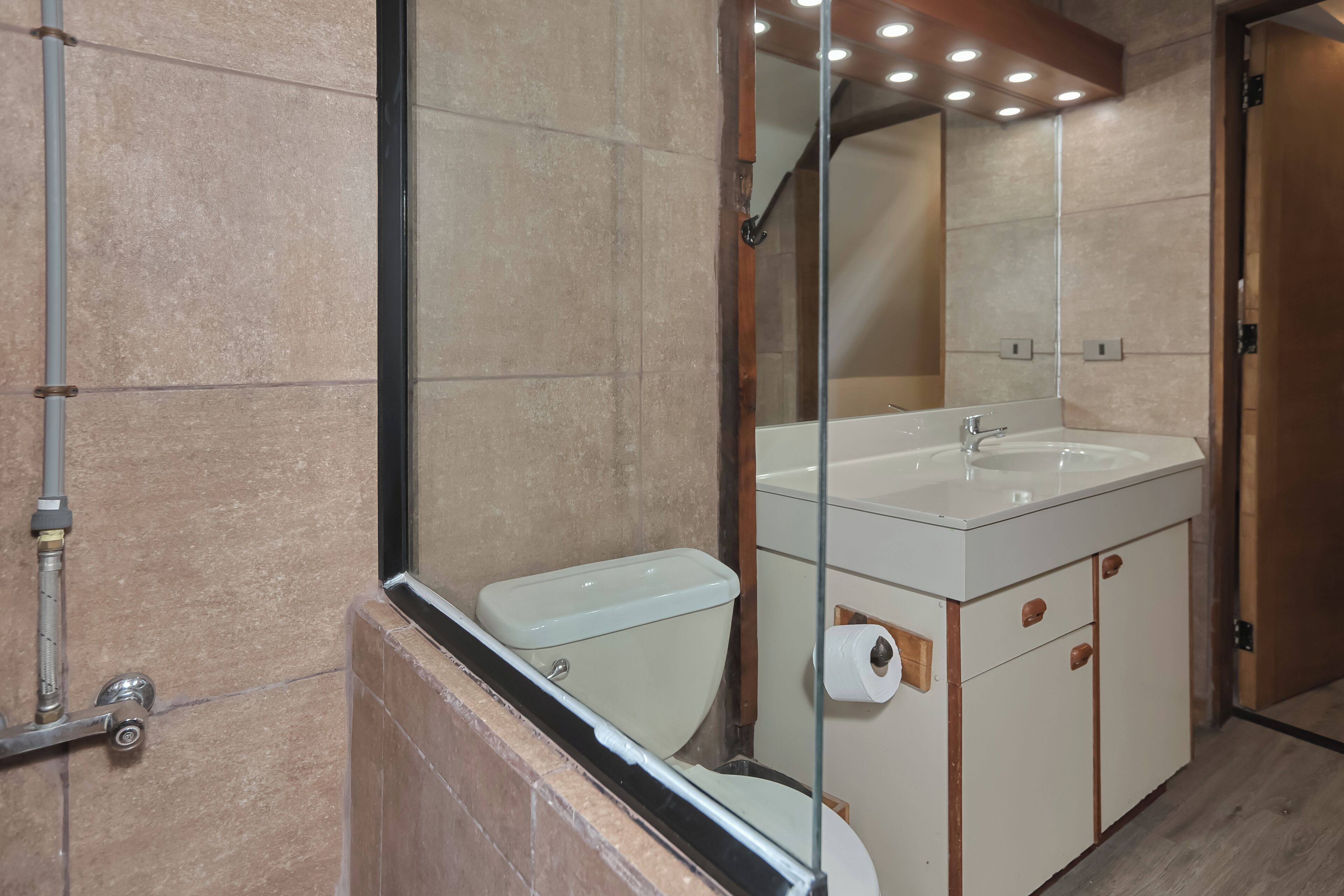 Ein Badezimmer mit Toilette, Waschbecken, Spiegel und Dusche.