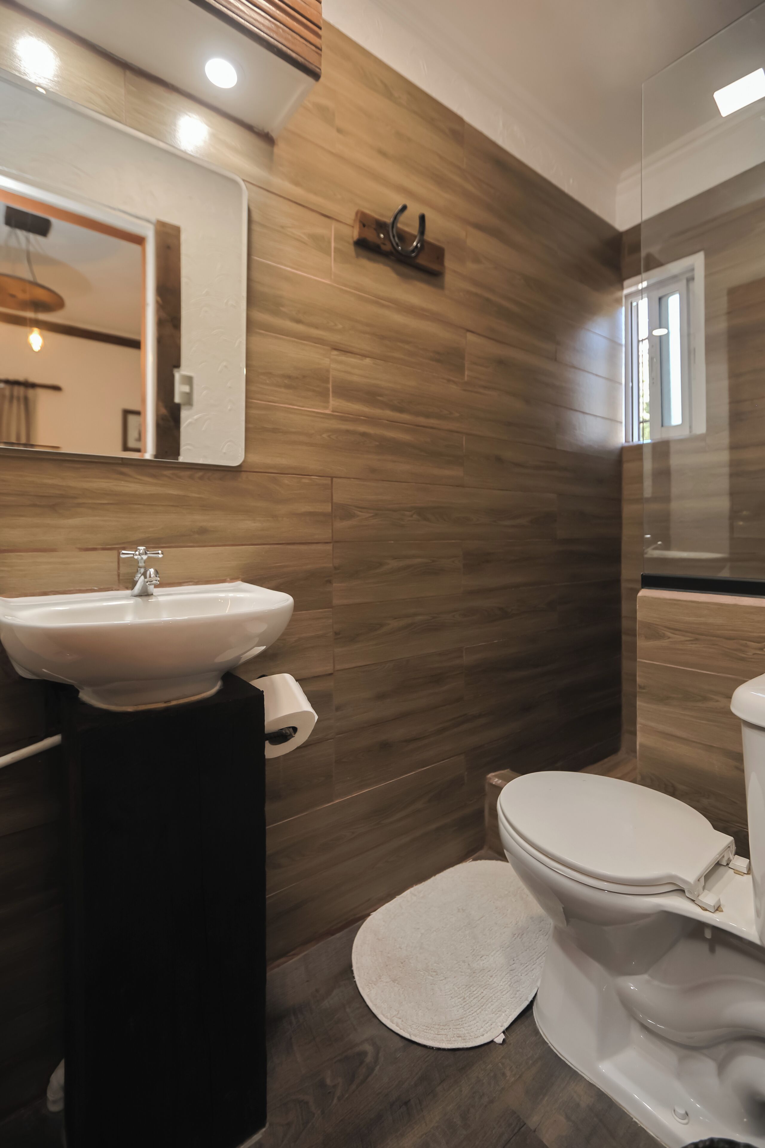Une salle de bain avec un lavabo, des toilettes et un miroir.