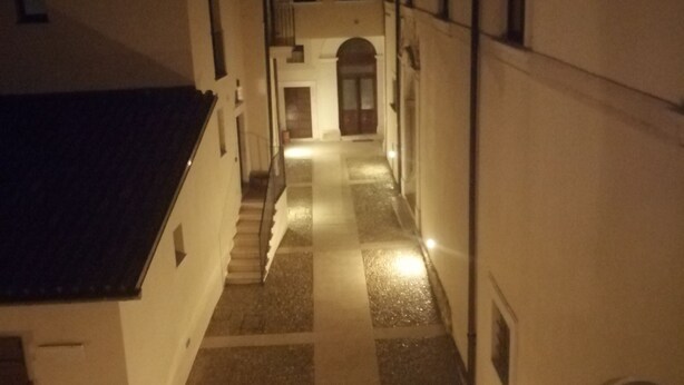 Une ruelle étroite, dallée de pierres, bordée de bâtiments des deux côtés.