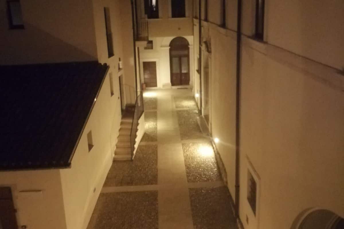 A narrow alleyway with cobblestone flooring and buildings on either side.