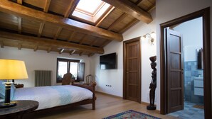 Une chambre à coucher avec un lit, une lampe, un téléviseur et un plafond en bois.