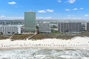 A beachfront hotel with multiple high-rise buildings, a sandy beach, and ocean waves. - Beachfront Gulf Condo! Renovated! Big Savings + Gorgeous Views! (Orange Beach)