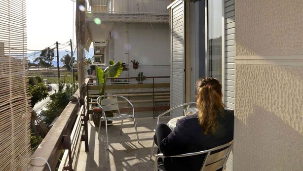 A balcony with a table, chairs, and a potted plant. - 3 bedroom apartment in Nafplio (Nafplio)