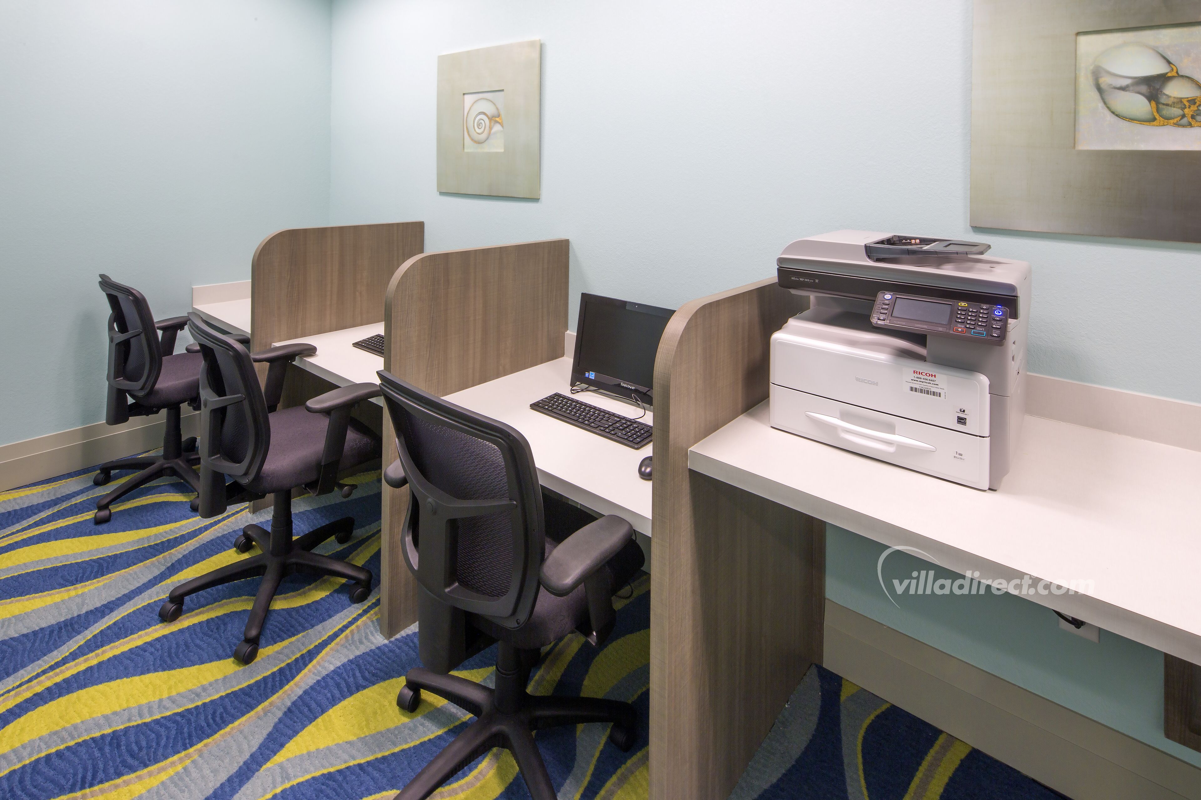 Een vergaderruimte met vier individuele werkplekken, elk voorzien van een laptop, een printer en een stoel.