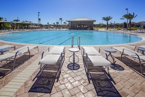 Ein Schwimmbecken mit Liegestühlen und einer überdachten Pergola.