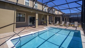 A swimming pool with a glass ceiling, surrounded by lounge chairs and a patio area. - Moon Valley by VillaDirect (Davenport)