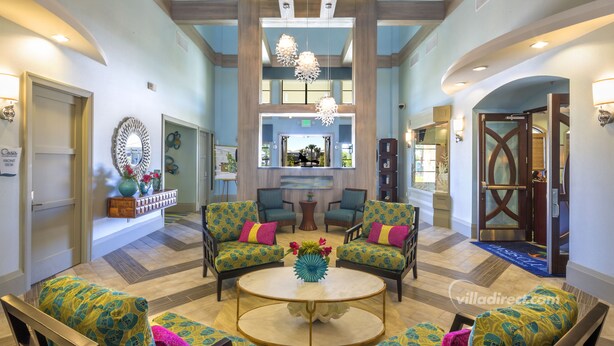 A spacious lobby with a central coffee table, four patterned armchairs, and a large mirror above the seating area. - Moon Valley by VillaDirect (Davenport)