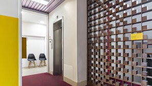 Ein Korridor mit rotem Teppich, gelber Wand und einer Holzwand mit Stauraum.
