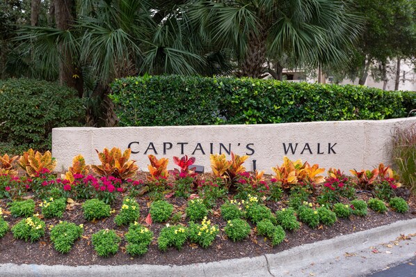 A sign for Captain's Walk with a landscaped garden in front. - Captains Walk Fifth Floor - Closest Direct Ocean Front, Captains Walk - closet direct oceanfront (Hilton Head Island)