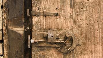 A rustic wooden door with a metal latch and lock mechanism.