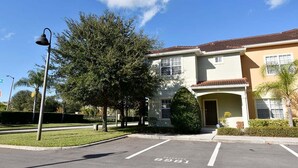 A two-story building with a flat roof, a front entrance, and a parking lot. - Dog-Friendly · Dual Masters · Private Pool · Resort Amenities · Near Disney (Kissimmee)